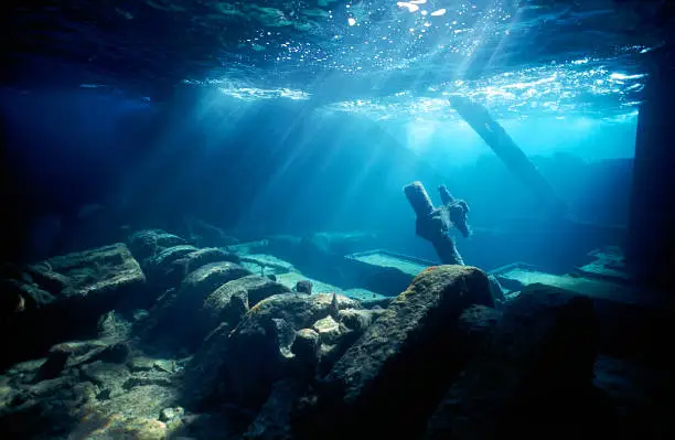 Inside the engine room of a shipwreck as the sunbeam streak in from the surface. Image was taken with a Nikonos V professional underwater camera system.