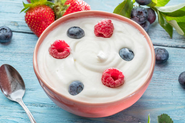 istock Ceramic bowl with plain yoghurt and berries on the table. Light summer mood. 1370299336