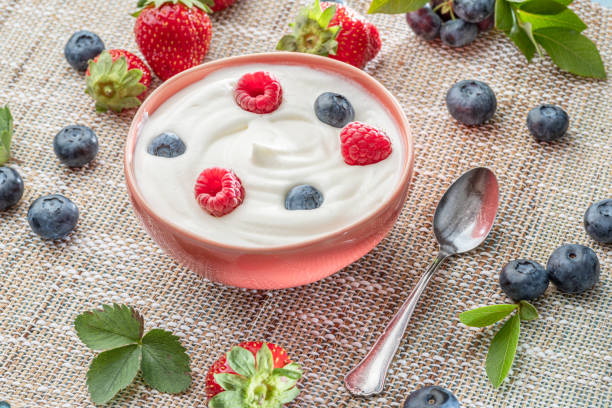 istock Ceramic bowl with plain yoghurt and berries on the table. Light summer mood. 1370299473