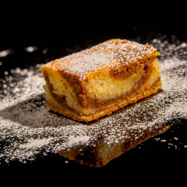 istock Besquit, cake on a black background, sprinkled with powdered sugar, dark and light layer of beckett on a black background, copy space 1370300926