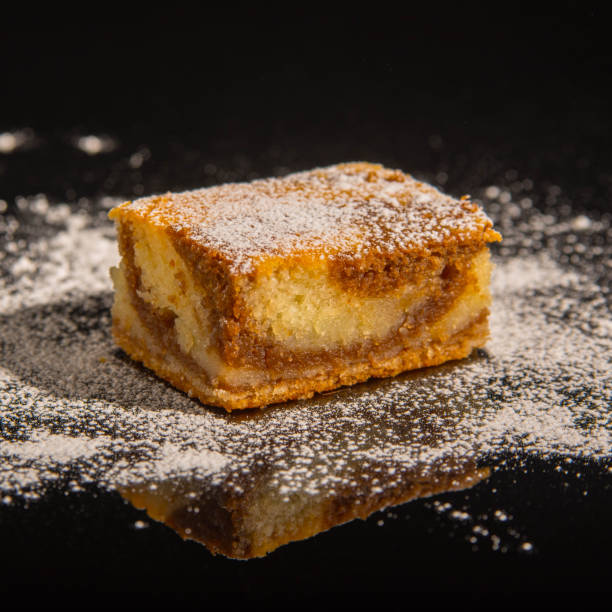 istock Besquit, cake on a black background, sprinkled with powdered sugar, dark and light layer of beckett on a black background, copy space 1370301620
