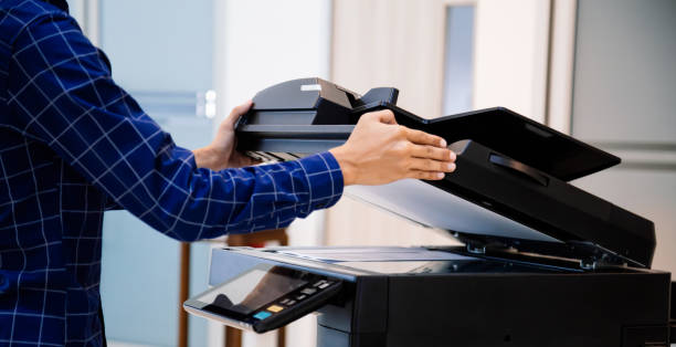 istock Businessmen press button on the panel for using photocopier or printer for printout and scanning document paper at office. 1370302194