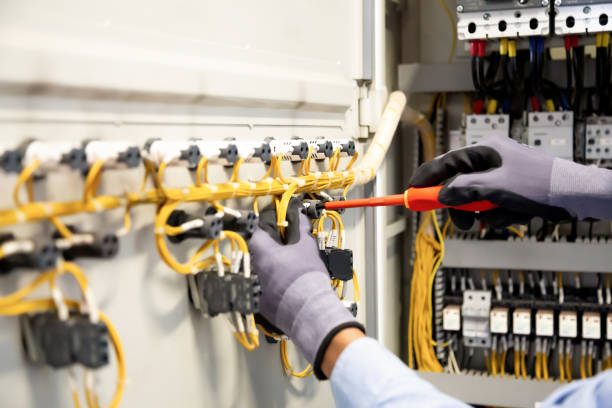 istock Electricians work to connect electric wires in the system, switchboard, electrical system in Control cabinet. 1370302834