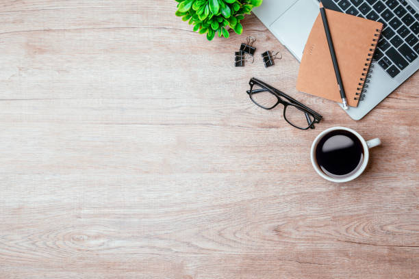 istock Work from home. desk office with laptop, blank notepad, coffee cup and pen on wood table. Flat lay top view copy spce. 1370303187