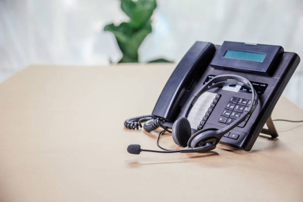 istock Communication support, call center and customer service help desk. telephone devices with VOIP headset in office.Customer service support (call center) concept. 1370303235