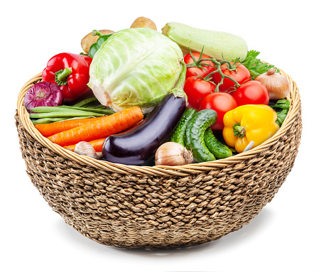 Food basket. Vast of different vegetables in the wicker basket on white background.