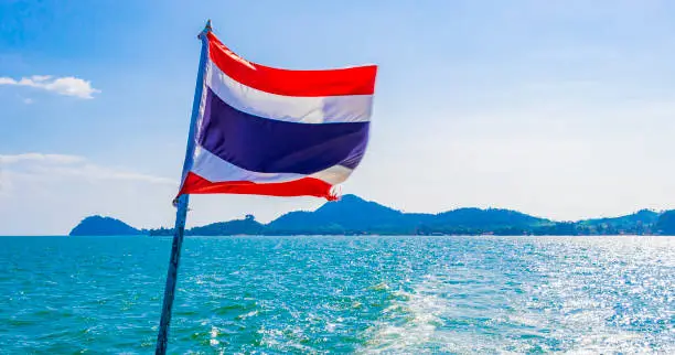 The national flag of Thailand in the rough wind and blue sky at island Koh Phayam in Ranong Thailand.