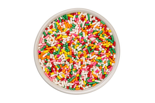 istock Top view of multicolored rainbow sugar sprinkles in white ceramic cup. 1370305154