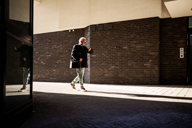 istock Grey haired senior businessman going to office checking the time 1370307767