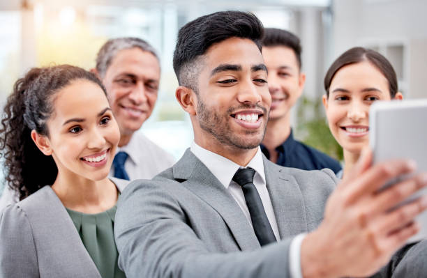 istock Shot of a group of staff taking selfies using a digital tablet 1370309217