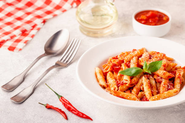 istock Classic italian pasta penne alla arrabiata with fresh basil on a light background, selective focus 1370309806