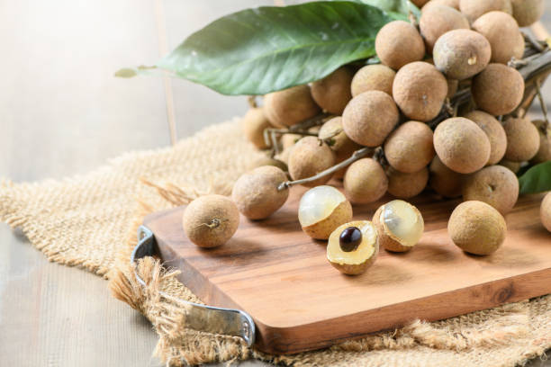 Fresh longan fruits on wood plate and old wood background, Fresh longan fruits on wood plate and old wood background, Asia fruit longan stock pictures, royalty-free photos & images