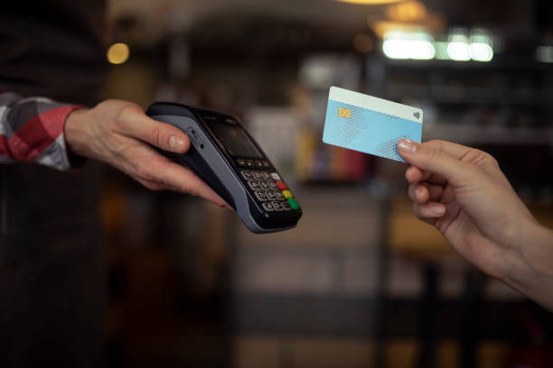istock Young woman using credit card in restaurant for payment. 1370315636