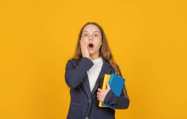 istock study with workbook. surprised child holding book. back to school. childhood education. 1370315902