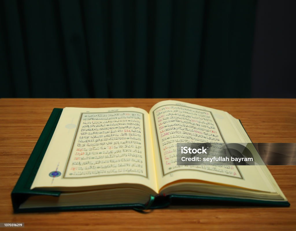 opened quran on table. verses with arabic letter opened quran on table. verses with arabic letter. Reading koran. Sufism Stock Photo