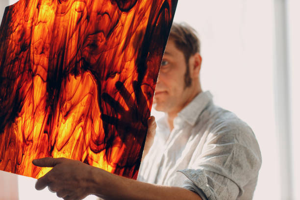 Craftsman artisan stained glass master male checking through surreal abstract pattern glass window
