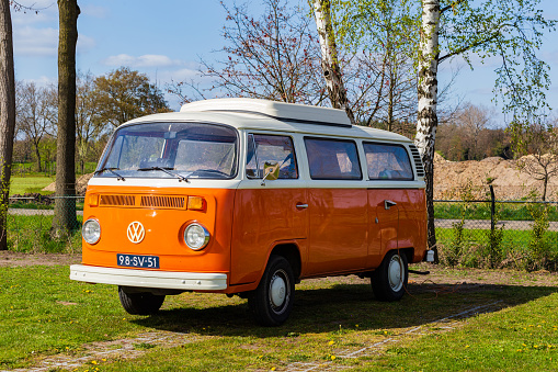 Diepenheim, The Netherlands - April 25, 2021: Classic orange VW camper van parked at a campsite in Hof van Twente in The Netherlands