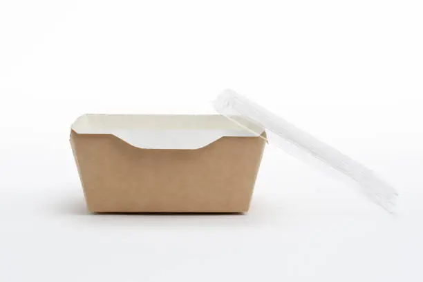 Photo of Paper eco-friendly container for food delivery with a transparent lid on a white background