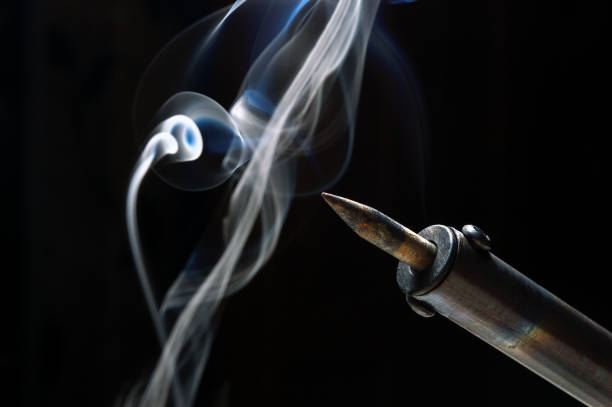 istock heated soldering iron with rosin smoke. dark background. close-up. 1370321985