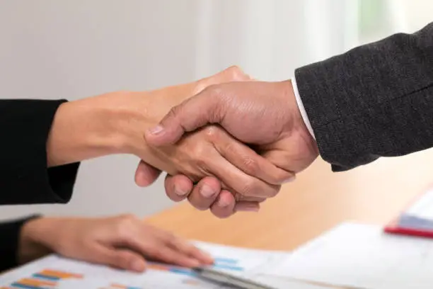 Confident business man and woman shaking hands during a meeting in the office, succession with dealing or greeting partner concept