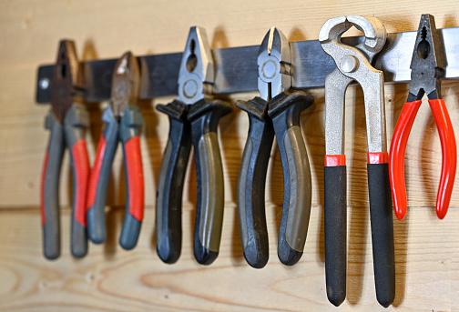 various sorts of pliers hanging on magnet hanger
