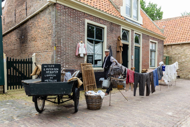 Scenery of Zuiderzee museum in Enkhuizen The Netherlands Enkhuizen, The Netherlands - July 7, 2021: Man in traditional cloths in front of his outdoor cloth shop in the streets of Zuiderzee museum in Enkhuizen North-Holland in The Netherlands enkhuizen stock pictures, royalty-free photos & images
