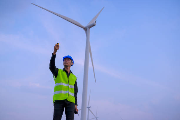 istock Blue collar worker at electricity site. Windmill field. 1370324925