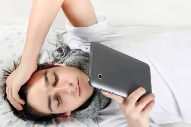 Young Man with Tablet Computer on the bed