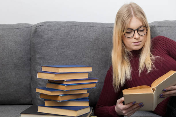istock Young woman is reading book at home closeup. 1370326412