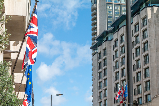 Union Jack and EU Flag in City of Westminster, London with commercial flags visible.