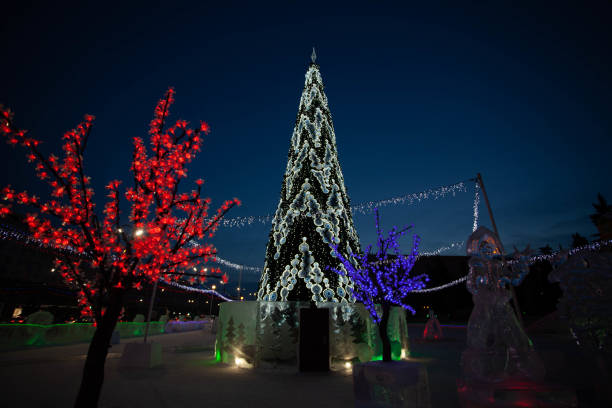istock Christmas tree with lights on the town square at night 1370330318