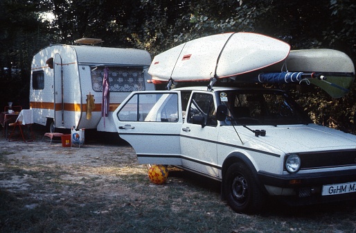 Near Arles, Provence-Alpes-Côte d'Azur, France, 1983. Campers with their car and trailer on a southern French campsite. Also: sports equipment.