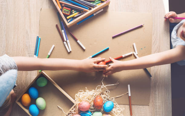 istock Children prepare for easter. Kids painting easter eggs. Easter background, flat lay, top view. 1370333414