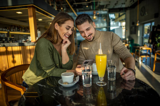istock Couple in cafe using mobile phone 1370335253