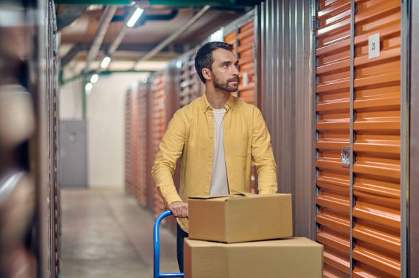 istock Worker wheeling the warehouse trolley with packaged goods 1370336206