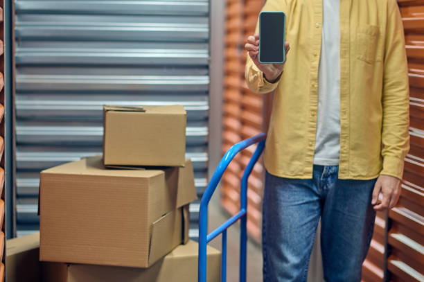 istock Storehouse worker holding his phone before the camera 1370336220