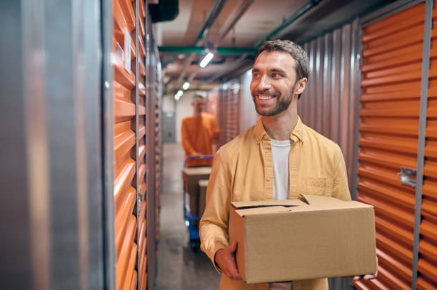 istock Joyful storehouse employee and his coworker unloading goods 1370336277