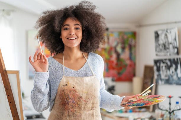 istock Smiling afro female fine artist  drawing in studio 1370336301