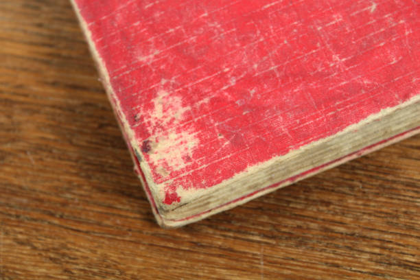 istock Old Red Book with Worn Out Cover on a Wood Surface 1370336871
