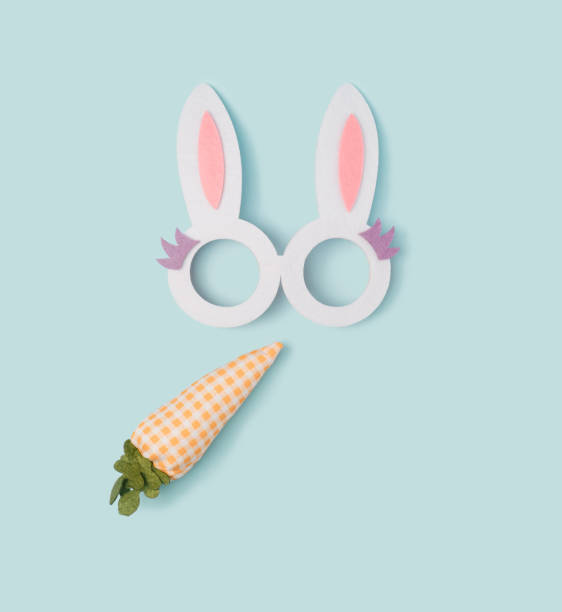 istock Decorative bunny ears with fabric carrot on a pastel blue background. 1370336882