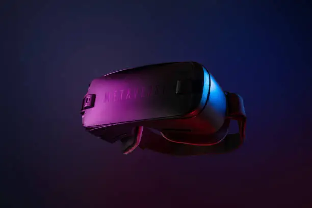 Photo of Metaverse. Future game and entertainment digital technology. VR virtual reality glasses isolated on dark blue purple background.