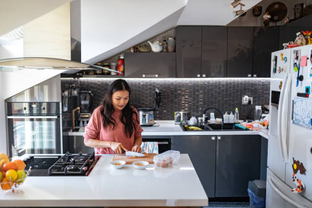 istock An Asian woman prepares lunch in her kitchen. 1370340318