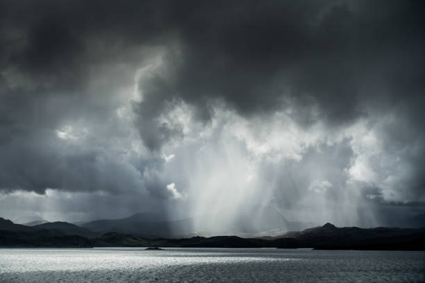 A heavy downpour as an early summer rain storm breaks over the Torridon mountains and the sea on the West Coast of Scotland.