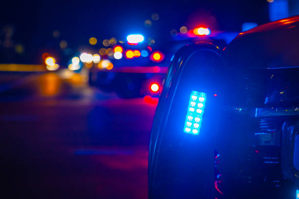 Generic crime scene police lights Blue police light flashes on a generic crime scene at night in an urban area. cordon tape stock pictures, royalty-free photos & images