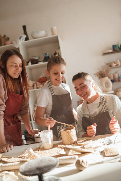 istock Mother and son learning pottery from professional 1370341770