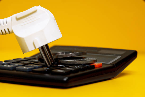istock Electricity growth concept. Calculator and AC power plug. 1370342256