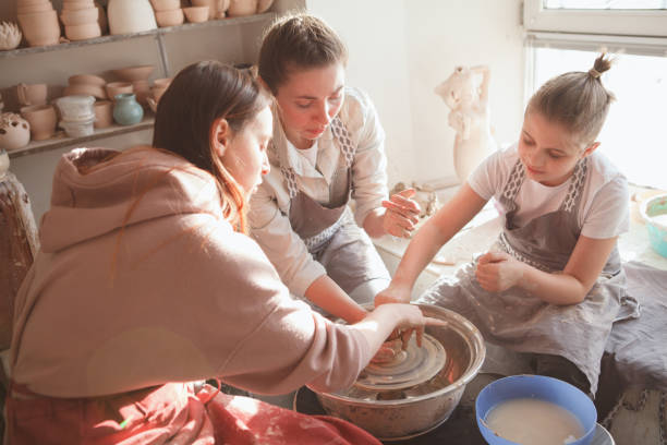 istock Mother and son learning pottery from professional 1370343279