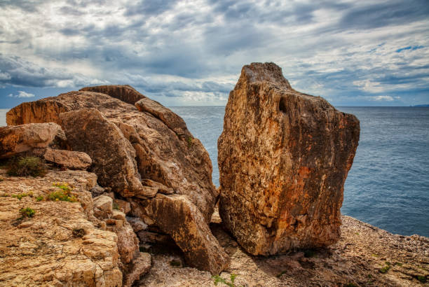 Rocky beach under a gloomy dramatic sky. Mallorca island, Spain Mediterranean Sea, Balearic Islands.