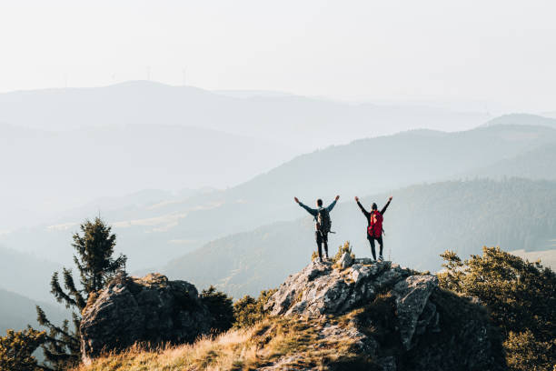istock Young couple with backpacks celebrate on a mountain summit 1370346093