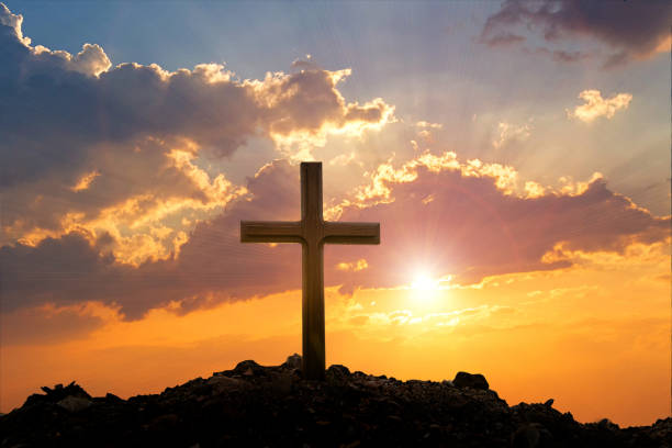 istock Cross on mountain sunset background. Easter concept. Concept conceptual black cross religion symbol silhouette in grass over sunset or sunrise sky. 1370346307